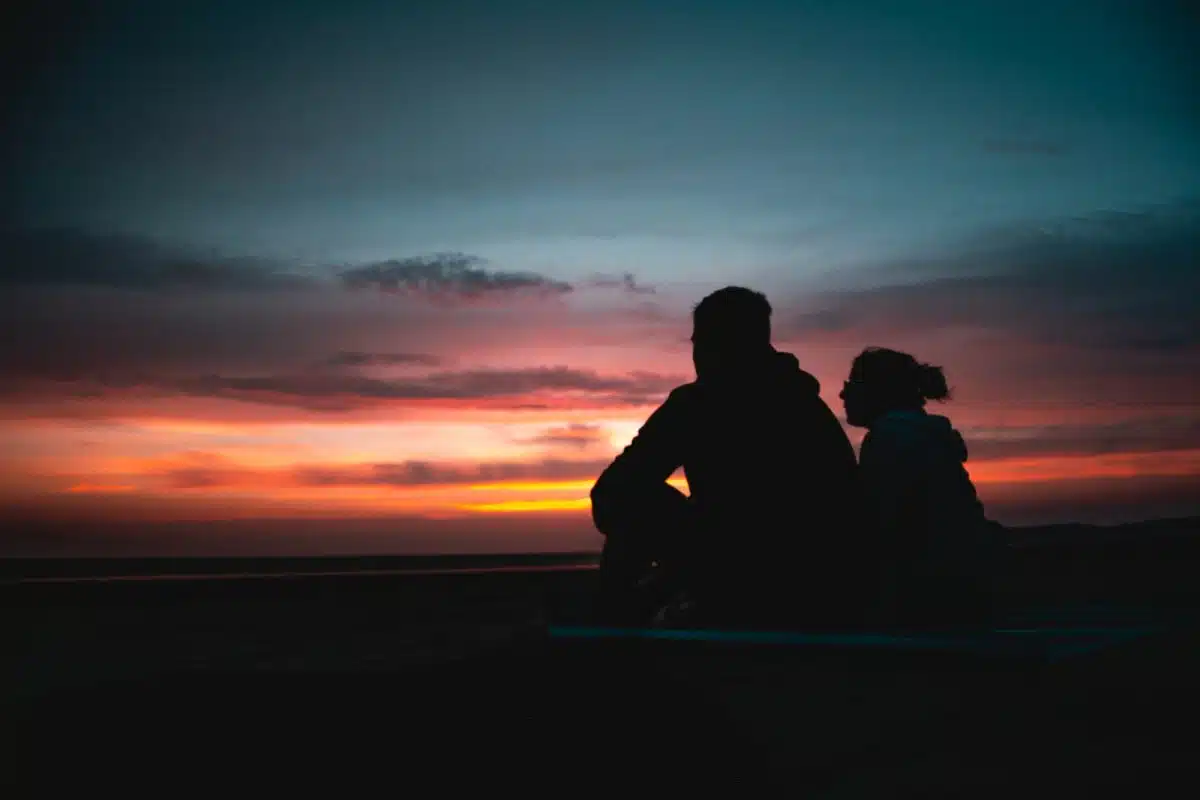 two person sitting during golden hour